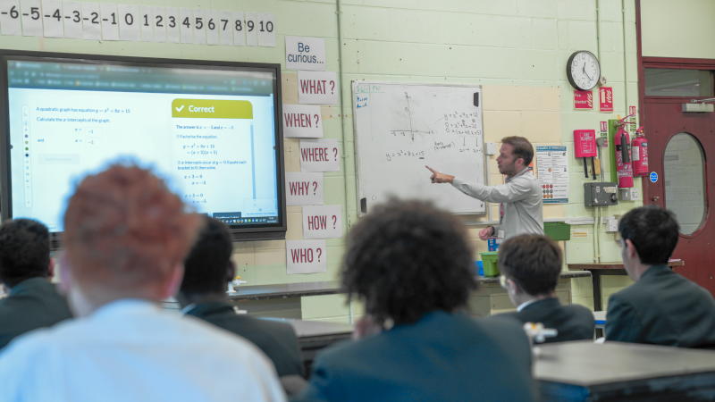 Teacher and students viewing Dr Frost Maths questions on a classroom screen